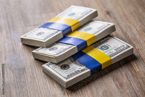 Bundles of dollar bills tied with the Ukrainian flag. The concept of support of the American government, for the war-torn