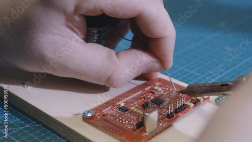 Male hands replace smd elements by soldering. Repair of electronic devices, tin soldering of parts. Repair of microcircuits with a soldering iron.
