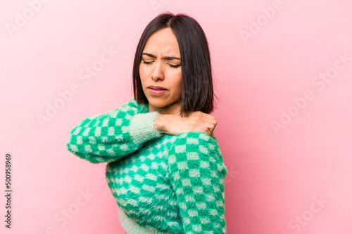 Young hispanic woman isolated on pink background having a shoulder pain.