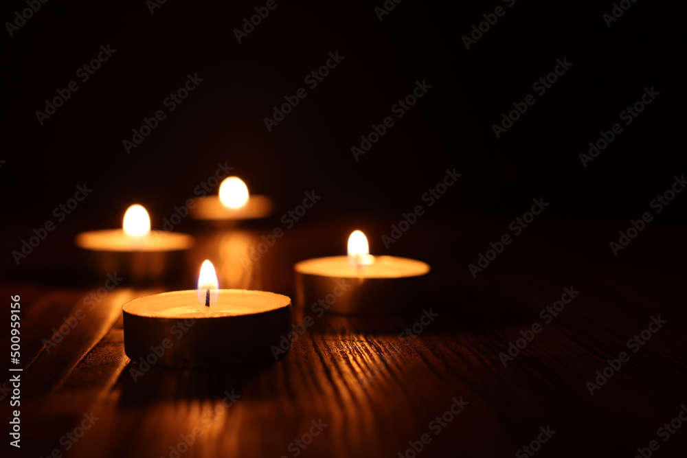 Burning candle over black background