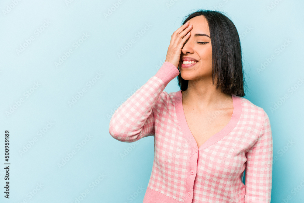 Young hispanic woman isolated on blue background laughing happy, carefree, natural emotion. Young hispanic woman isolated on blue background laughing happy, carefree, natural emotion.