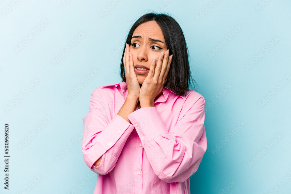 Young hispanic woman isolated on blue background scared and afraid. Young hispanic woman isolated on blue background scared and afraid.