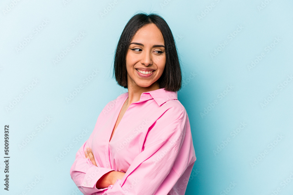 Young hispanic woman isolated on blue background laughing and having fun. Young hispanic woman isolated on blue background laughing and having fun.