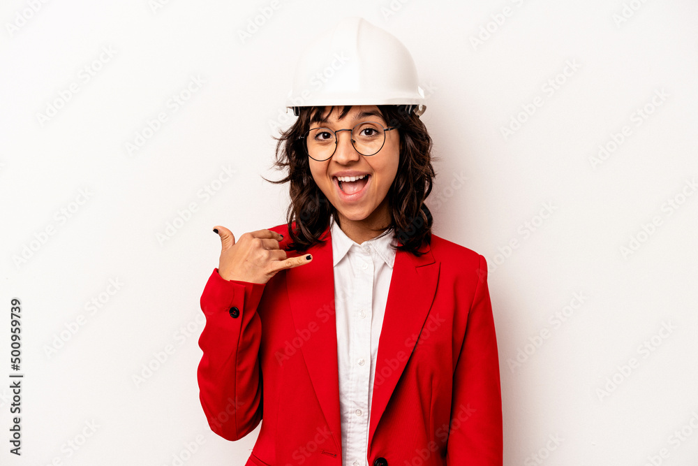 Young architect hispanic woman with helmet isolated on white background showing a mobile phone call gesture with fingers. Young architect hispanic woman with helmet isolated on white background showing a mobile phone call gesture with fingers.