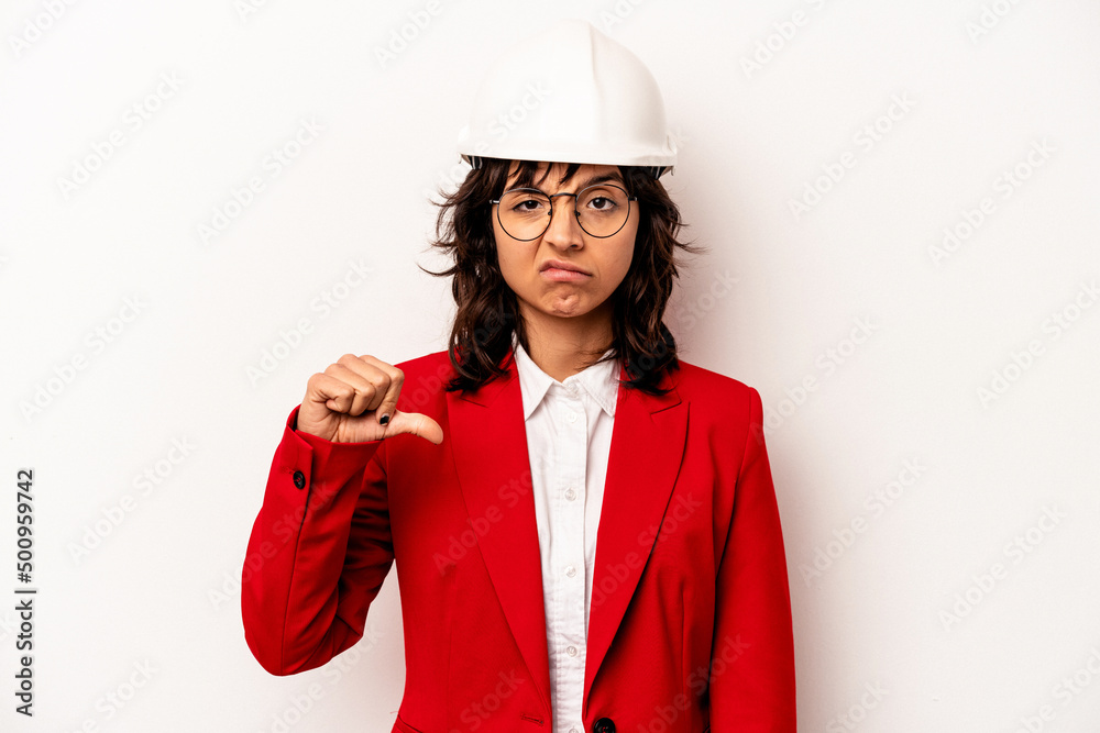 Young architect hispanic woman with helmet isolated on white background showing a dislike gesture, thumbs down. Disagreement concept. Young architect hispanic woman with helmet isolated on white background showing a dislike gesture, thumbs down. Disagreement concept.