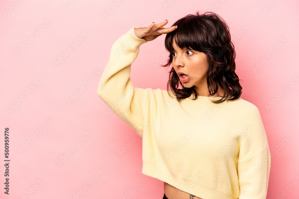 Young hispanic woman isolated on pink background looking far away keeping hand on forehead. Young hispanic woman isolated on pink background looking far away keeping hand on forehead.