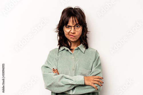 Young hispanic woman isolated on white background frowning face in displeasure, keeps arms folded.