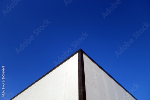 Commercial warehouse aluminium wall and roof against sky.