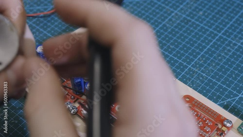 Soldering is done on the microchips in the factory with a soldering machine. electronic working hands.