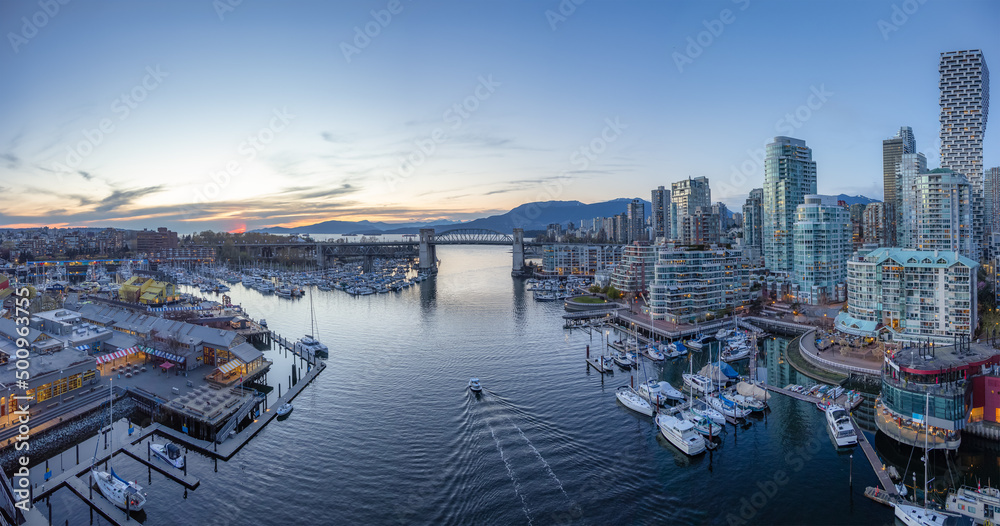 Panoramic Aerial View of False Creek with modern city skyline and mountains in background. Sunset Sky. Downtown Vancouver, British Columbia, Canada.