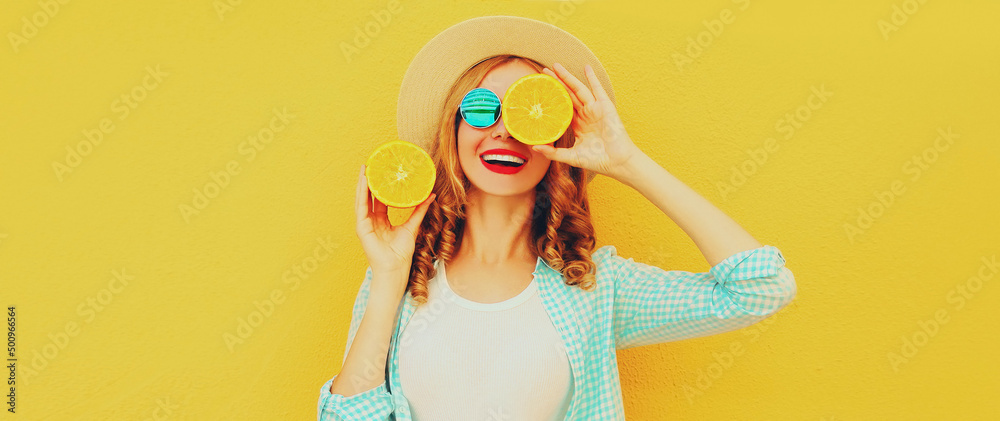 Summer portrait of happy smiling young woman with slices of fresh orange fruits wearing straw hat, sunglasses on yellow background Summer portrait of happy smiling young woman with slices of fresh orange fruits wearing straw hat, sunglasses on yellow background