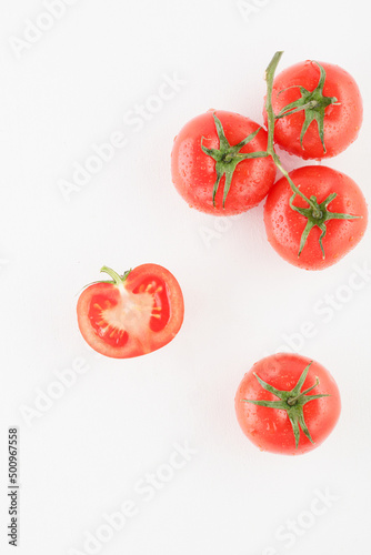 bunch of fresh red tomatoes with water drops on a white background