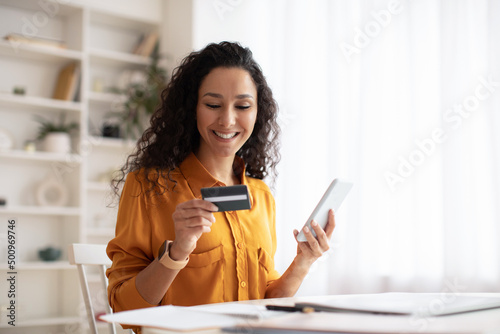 Happy Arabic Female Shopping Online Using Cellphone In Office photo