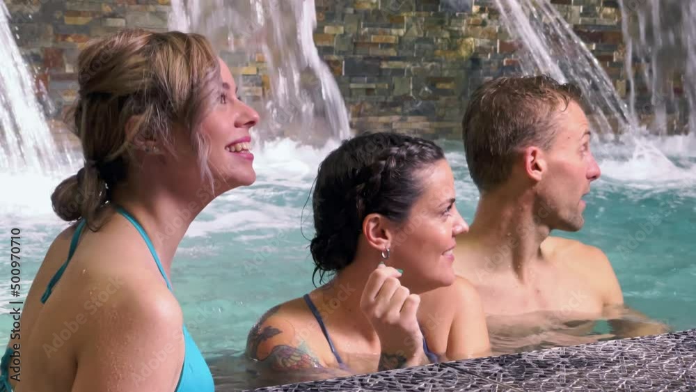 Group of 3 friends looking at somewhere else in spa pool Group of 3 friends looking at somewhere else in spa pool