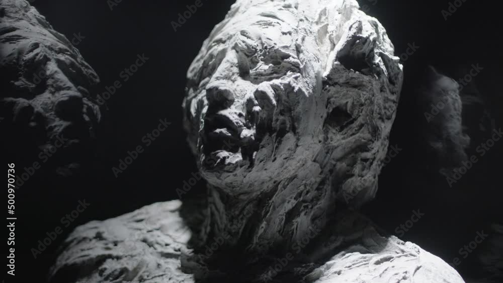 A white statue of a man. A close-up shot on a black background.
