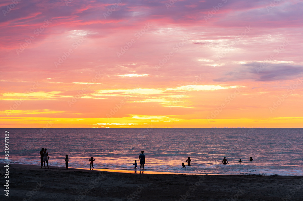 People silhouettes swimming in Pacific Ocean on Same beach between Atacames and Sua, Esmeraldas province, Ecuador.