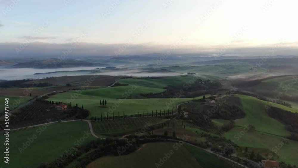 Cinematic 4k aerial video at golden hour of beautiful mansion in the lush rolling hills of Tuscany, Italy