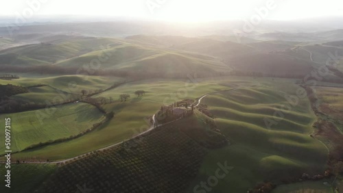 Cinematic 4k aerial video at golden hour of beautiful mansion in the lush rolling hills of Tuscany, Italy photo