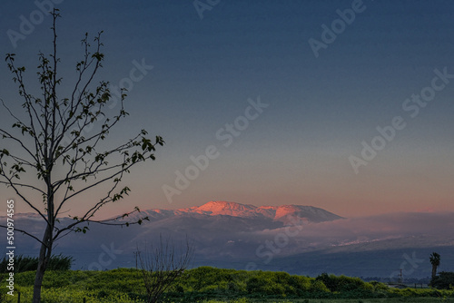 Sunset view of the Golan Heights and Mount Hermon  as seen from Hula valley, near Yesood HaMaala village, Upper Galilee, Israel.  photo
