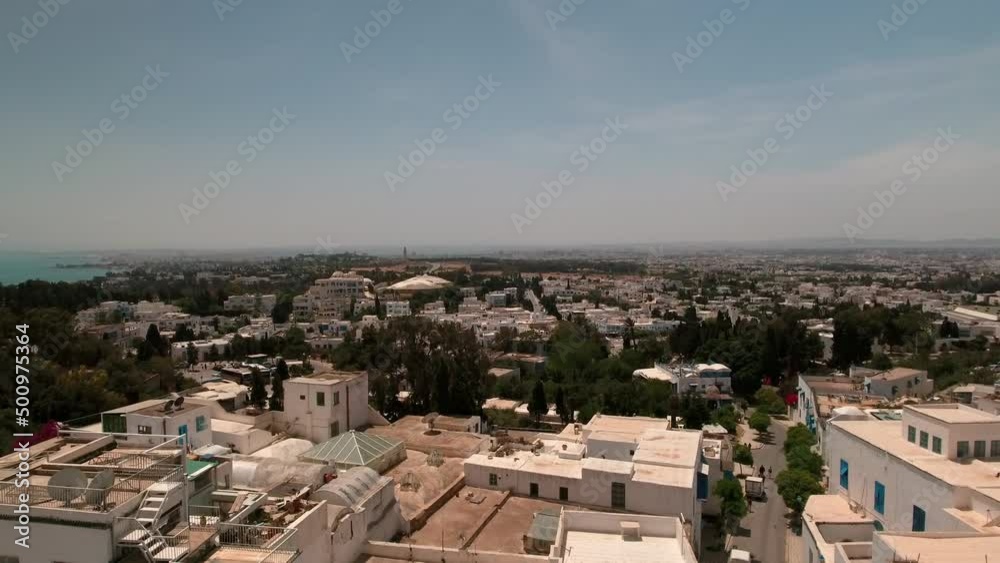 Aerial Forward Shot Of Beautiful White Buildings In Town On Hill During Sunny Day - Djerba, Tunisia Aerial Forward Shot Of Beautiful White Buildings In Town On Hill During Sunny Day - Djerba, Tunisia