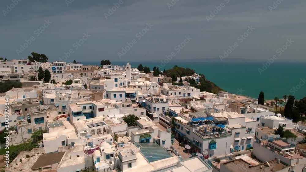 Aerial Backward Shot Of White Residential Buildings On Hill By Sea - Djerba, Tunisia Aerial Backward Shot Of White Residential Buildings On Hill By Sea - Djerba, Tunisia
