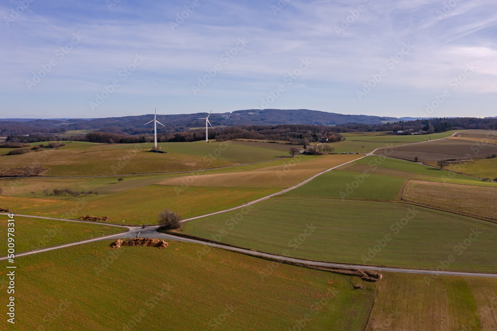 Two propellers of a wind turbine in the open field seen from a drone