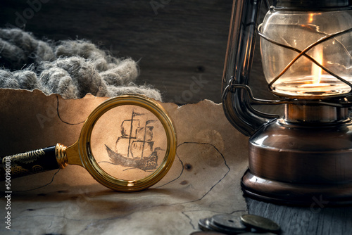 Columbus day. The concept of adventure and treasure hunting. an old map of pirate treasures, an old lamp, a ship's rope and coins on the table in the captain's cabin