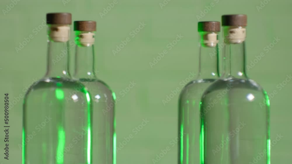 The bartender takes a bottle of alcohol from a table of several bottles of vodka against the background of a brick wall close-up The bartender takes a bottle of alcohol from a table of several bottles of vodka against the background of a brick wall close-up