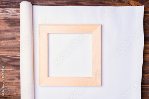 square wooden stretcher on a rolled roll of natural canvas for printing photos, top view
