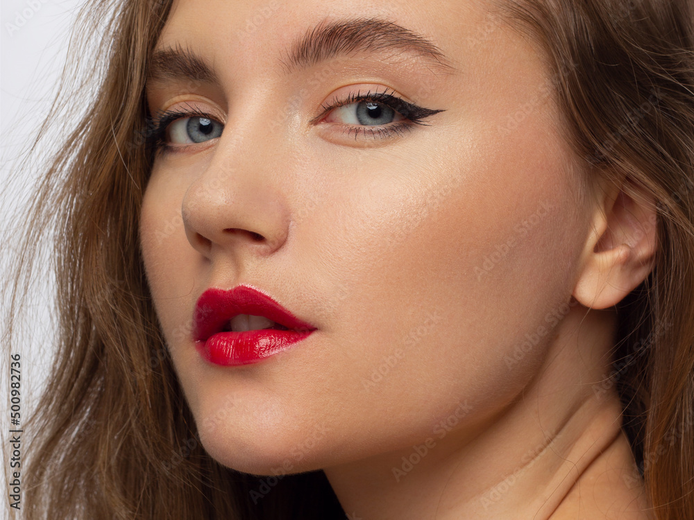 Close up portrait of a beautiful young female face with red lips and long brown hair. Classic make smoky shadows. Extremely long eyelashes and thick eyebrows. Cosmetology, spa, eyesight, injections Close up portrait of a beautiful young female face with red lips and long brown hair. Classic make smoky shadows. Extremely long eyelashes and thick eyebrows. Cosmetology, spa, eyesight, injections