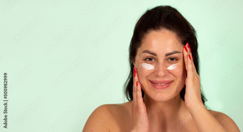 Mature Caucasian woman applying face cream skin care product age 30 to 40 Mature Caucasian woman applying face cream skin care product age 30 to 40