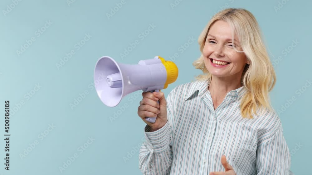 Promoter elderly gray-haired blonde woman lady 40s years old wear white shirt scream aside in megaphone announces discounts sale Hurry up isolated on plain pastel light blue background studio portrait Promoter elderly gray-haired blonde woman lady 40s years old wear white shirt scream aside in megaphone announces discounts sale Hurry up isolated on plain pastel light blue background studio portrait