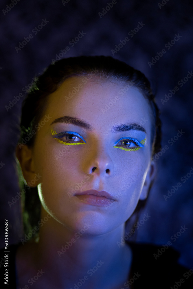 
portrait of a Ukrainian girl in the dark with make-up in the colors of the Ukrainian flag