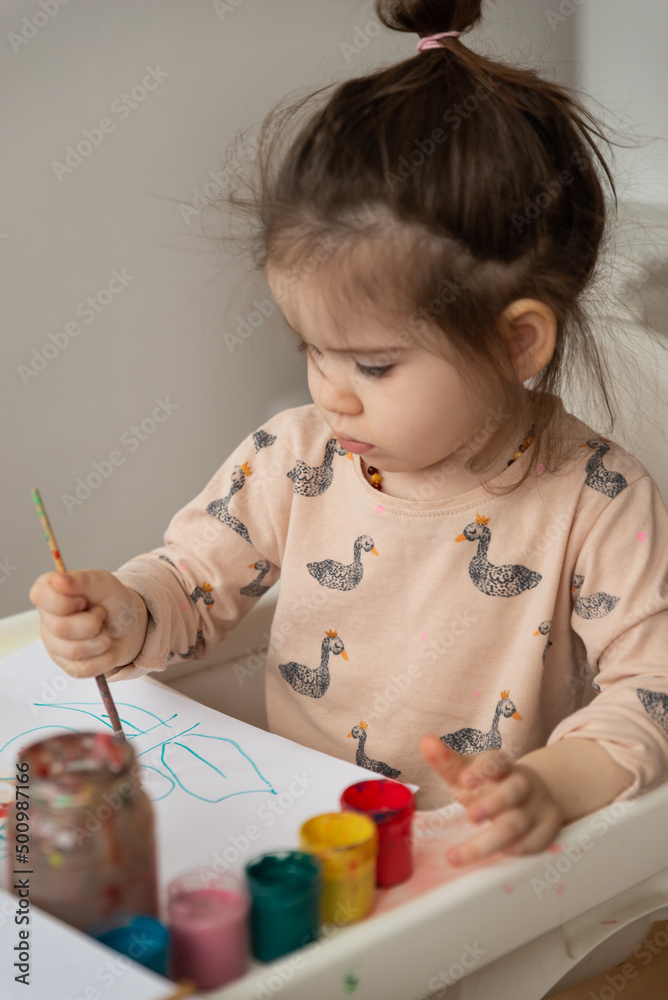 Pretty baby girl drawing with colourful paints at home. Pretty baby girl drawing with colourful paints at home.