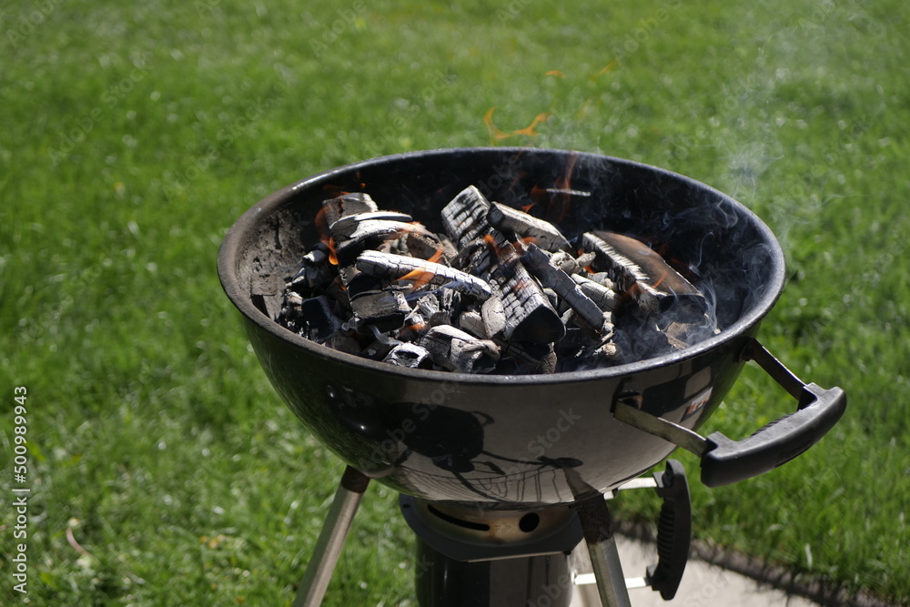 Barbeque grill heating up with charcoals on a suny day Barbeque grill heating up with charcoals on a suny day