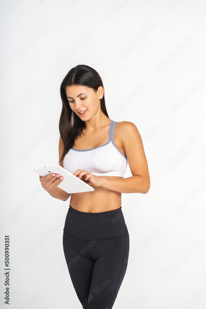 Athletic young woman using a tablet and smiling Athletic young woman using a tablet and smiling