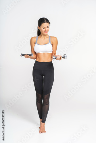 young woman with dumbbells on white background with copy space.