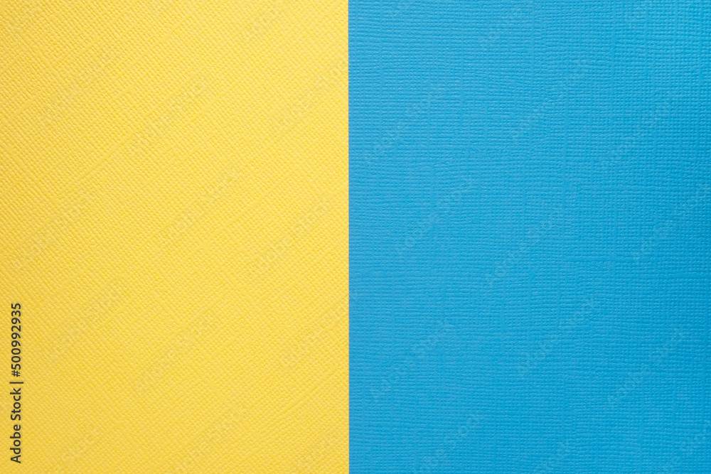 Fototapeta premium Two colored papers with a blue and yellow overlay on the floor. they divide half of the image. . High quality photo