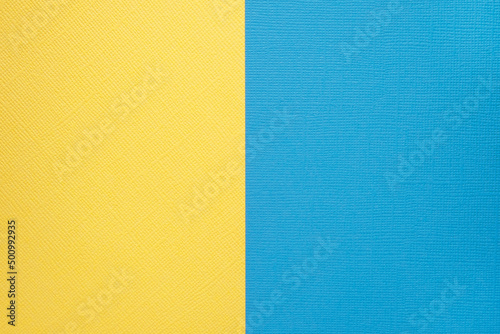 Two colored papers with a blue and yellow overlay on the floor. they divide half of the image. . High quality photo