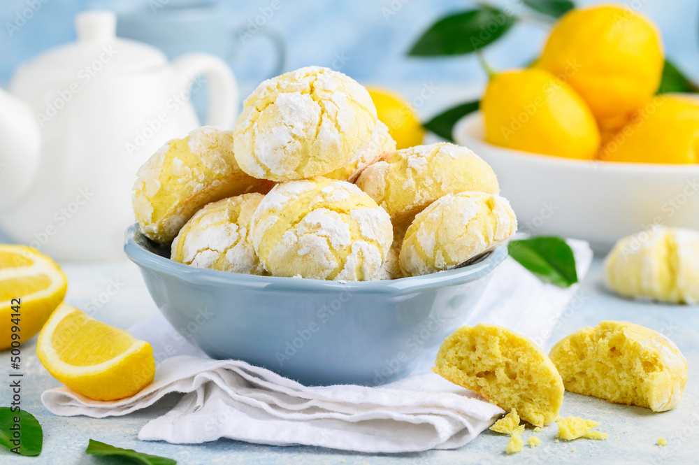 Cracked lemon biscuits or cookies on a blue plate. Citrus bakery. Healthy delicious dessert. selective focus Cracked lemon biscuits or cookies on a blue plate. Citrus bakery. Healthy delicious dessert. selective focus