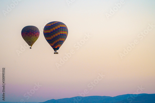 Colorful balloon flying over a clear sky during a sunset on a sunny day in Cappadocia, Turkey