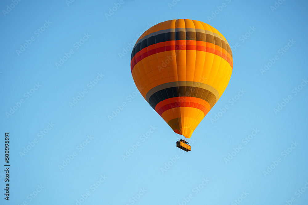 Colorful balloon flying over a clear blue sky during a sunset on a sunny day in Cappadocia, Turkey, copy space Colorful balloon flying over a clear blue sky during a sunset on a sunny day in Cappadocia, Turkey, copy space