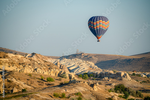 Colorful balloon flying over a clear blue sky during a sunset on a sunny day in Cappadocia, Turkey, copy space