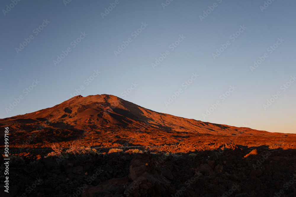 Sunset and scenic view of Mount Teide, a volcano on Tenerife in the Canary Islands, Spain. Beautiful golden hour light on the volcanic landscape and mountain.