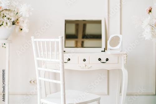 Foto White wooden dressing table in bright bedroom.