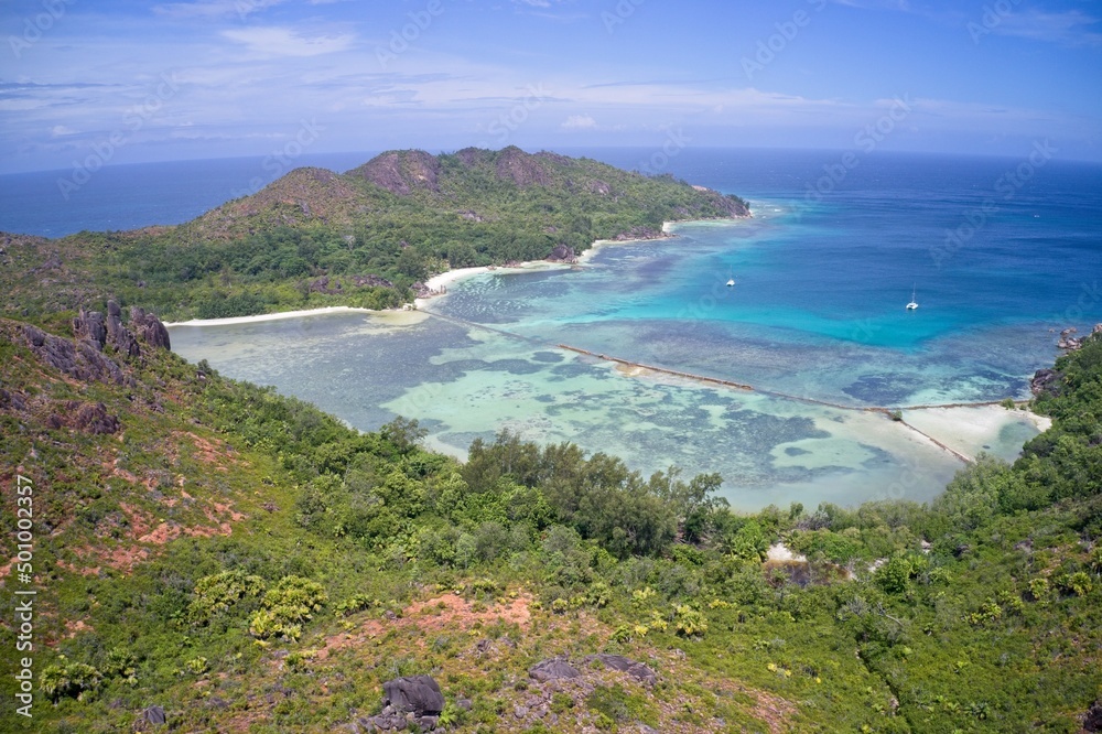 Aerial view of private cove with turquoise waters and green mountains on Curieuse Island, Seychelles.