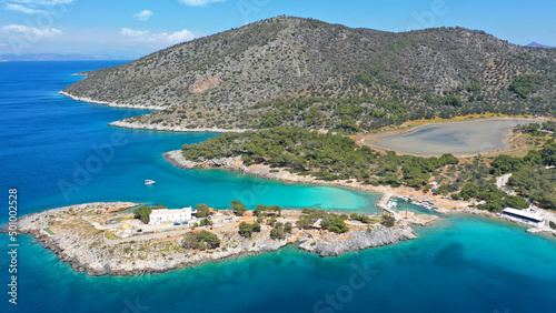 Aerial drone photo of iconic Aponisos bay and lake with clear turquoise sea and pine trees, Agistri island, Saronic gulf, Greece