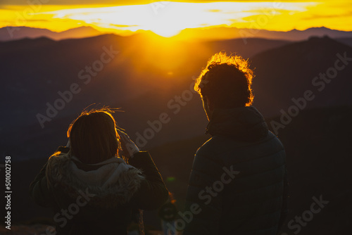 Leinwand Poster pareja tomando fotos del atardecer en la montaña
