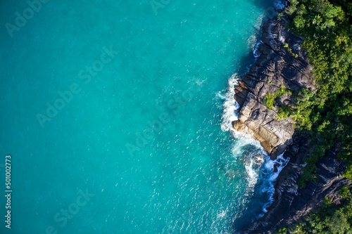 Drone field of view of secret cove with turquoise blue water meeting the forest on secluded island of Mahe, Seychelles.