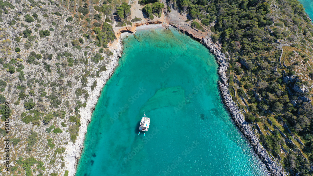Aerial drone photo of tropical exotic paradise island bay with deep turquoise sea forming a blue lagoon visited by luxury yachts and sail boats